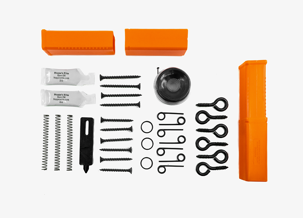 [An array of essential accessories for the Fith Ops Perimeter Trip alarm laid out on a white background, including multiple screws, springs, trip wire, extra pins and small gun oil.]]
